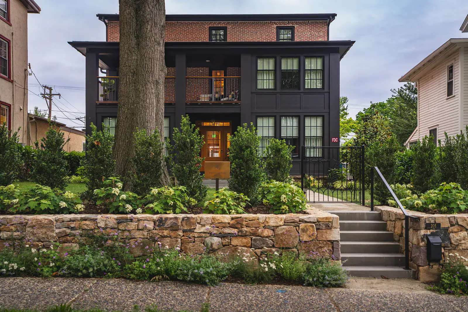 Pedestrian-friendly streetscape with natural stone walls, planting, and inviting public gathering spaces.